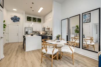 a dining room and kitchen area with a table and chairs